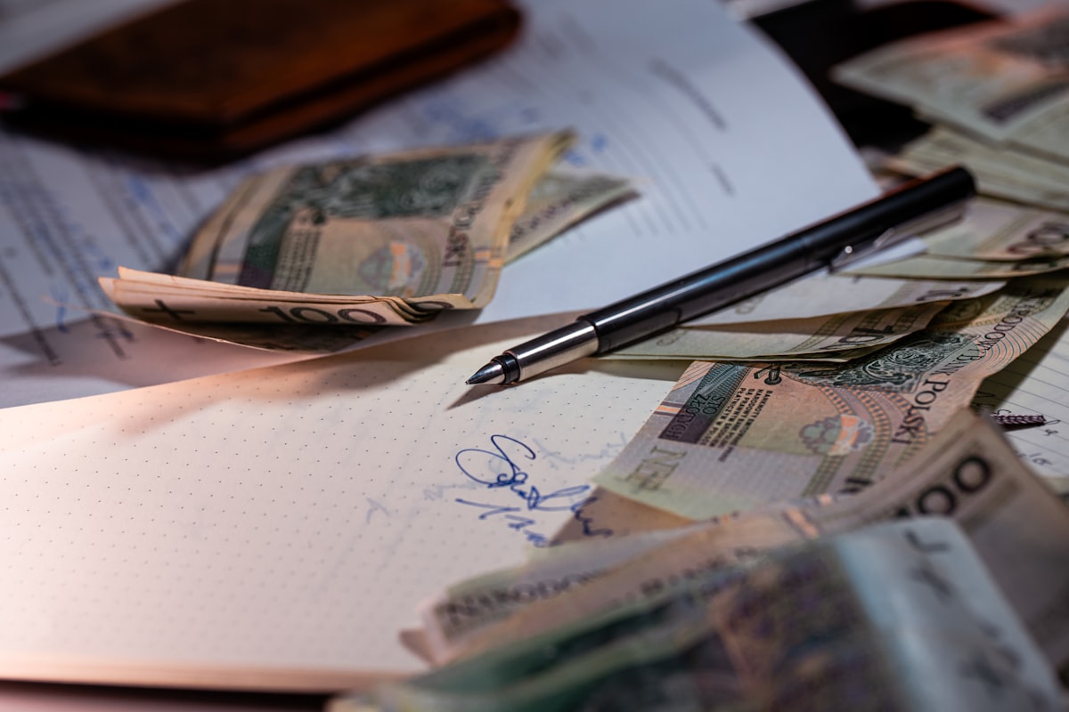 Pen and money scattered on financial documents