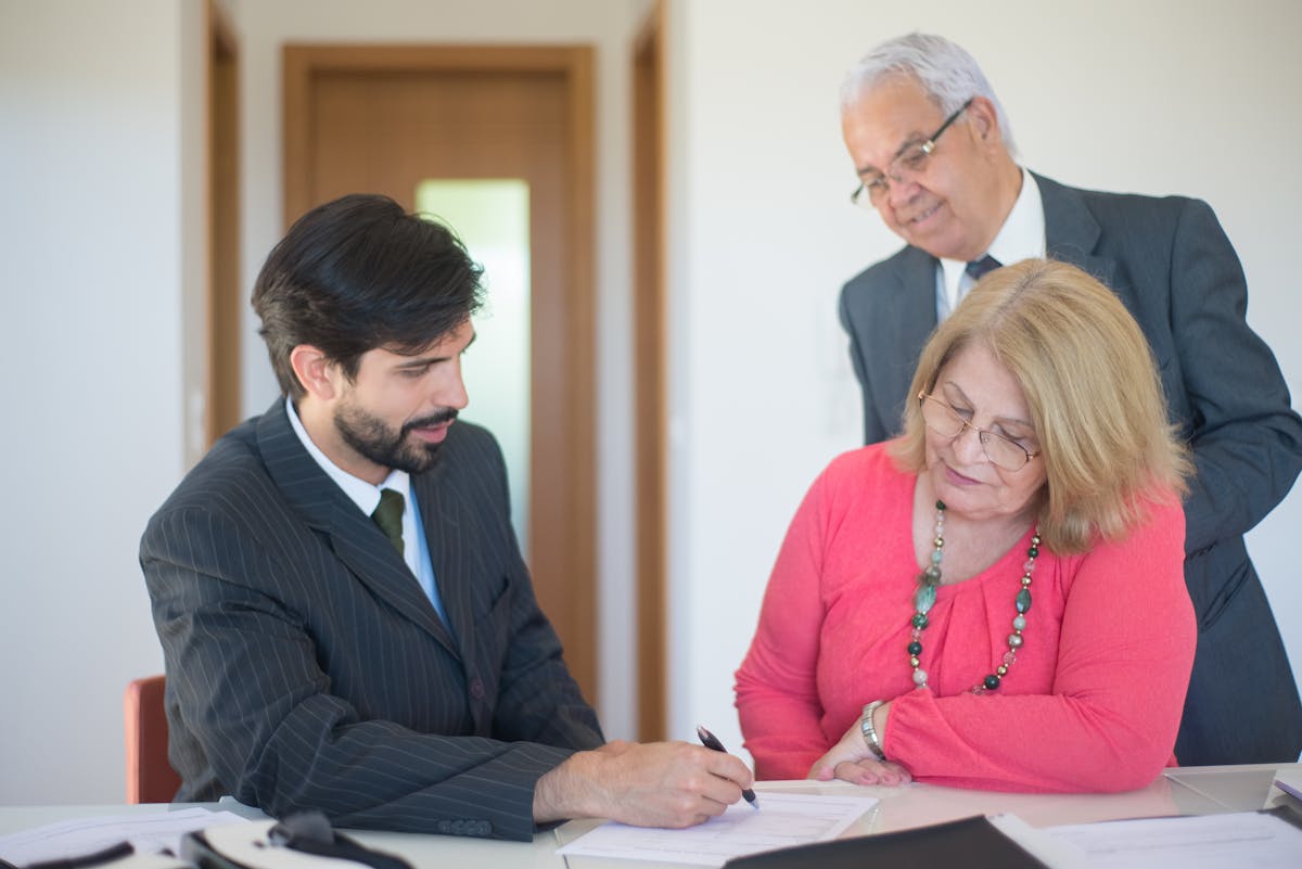 An older adult signing a lasting power of attorney document with a solicitor