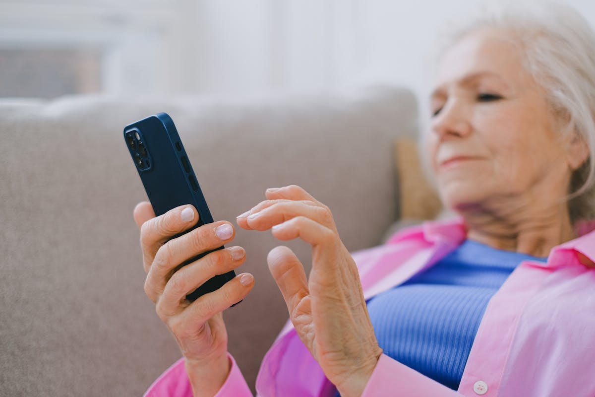 An older woman using a smartphone to check her NHS hospital appointment in the NHS App