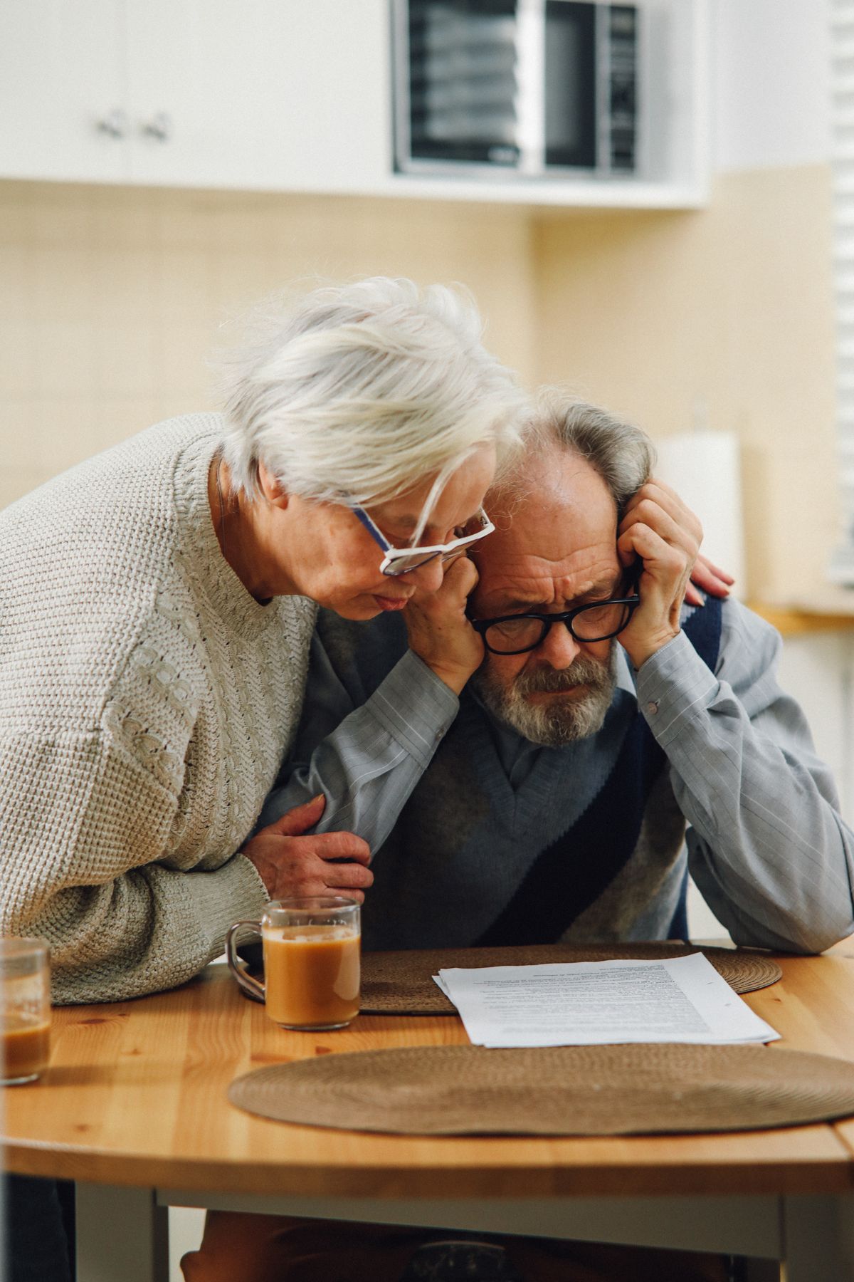 An older couple sitting at a table reviewing financial documents about their pension and estate planning