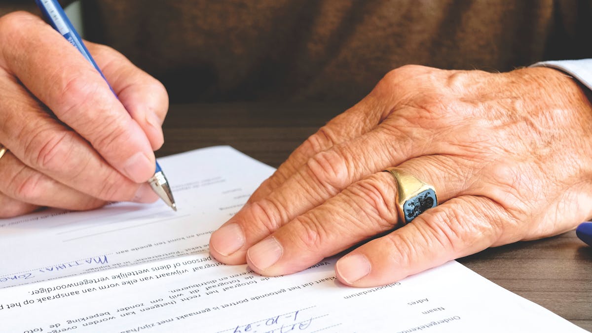 Person signing legal documents at a desk — UK probate guide