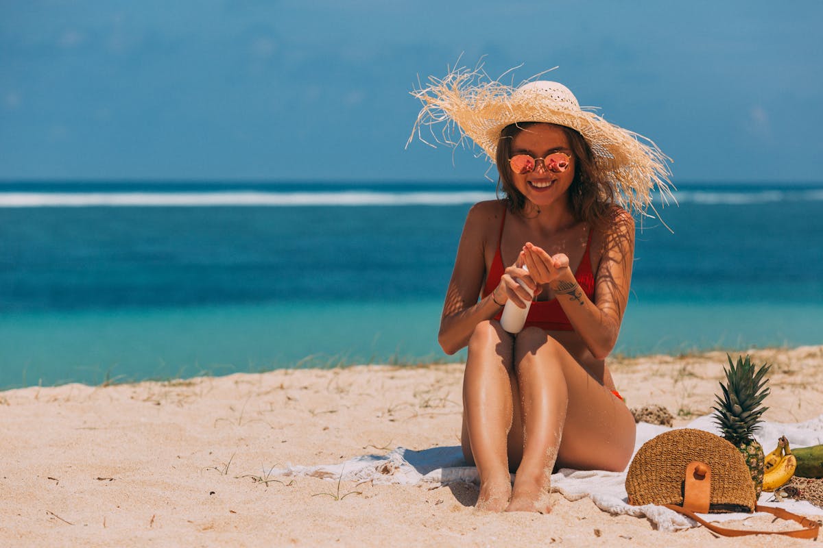 A person applying sunscreen on a sunny day to protect against skin cancer