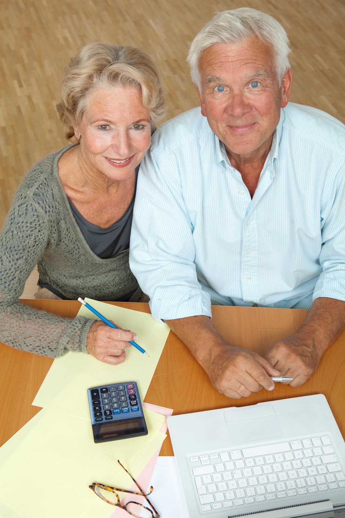 A couple in their 60s reviewing retirement finances on a laptop