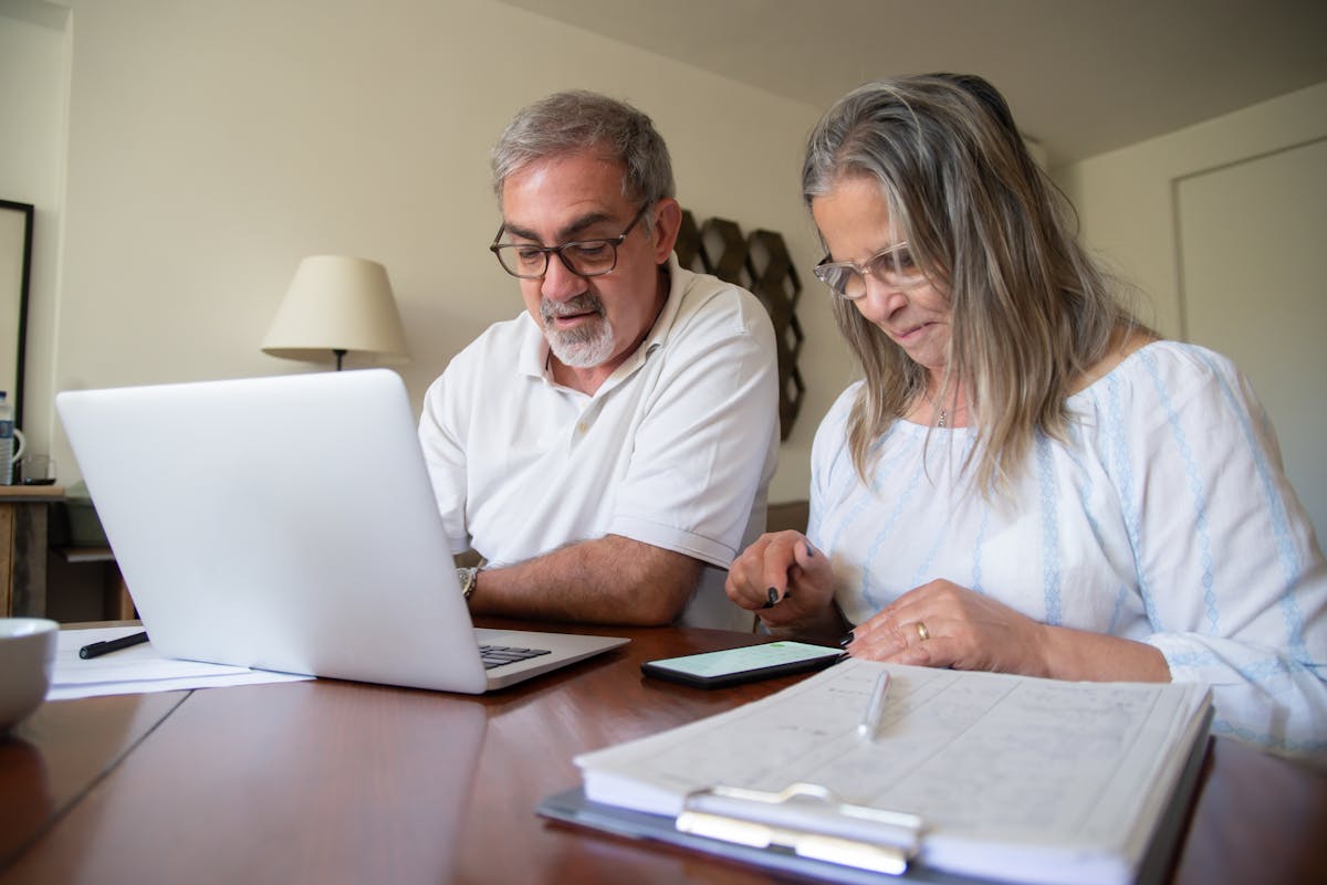 Older couple reviewing financial documents and planning their retirement at home