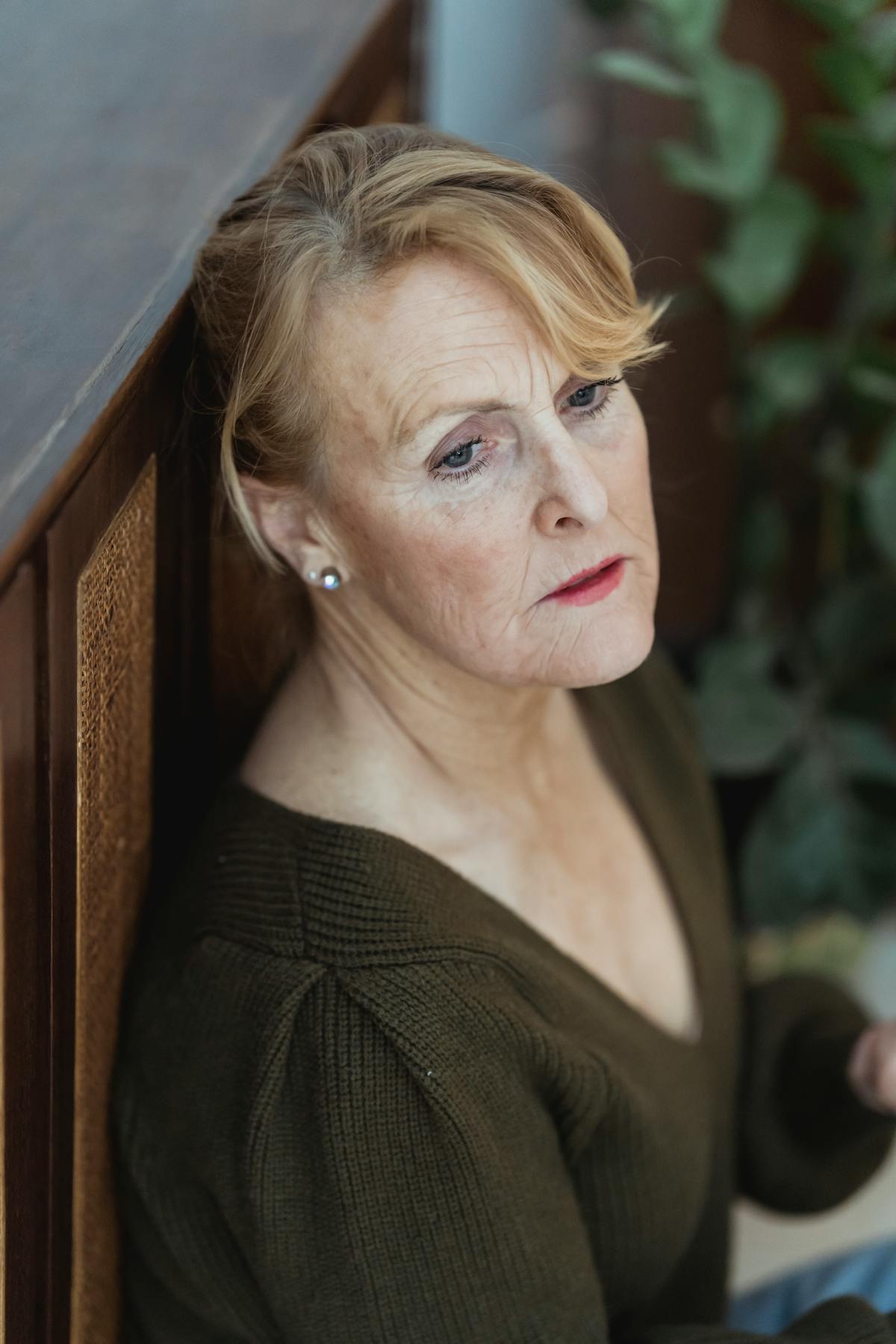 A woman looking concerned while holding a smartphone, illustrating the worry caused by voice cloning scam calls