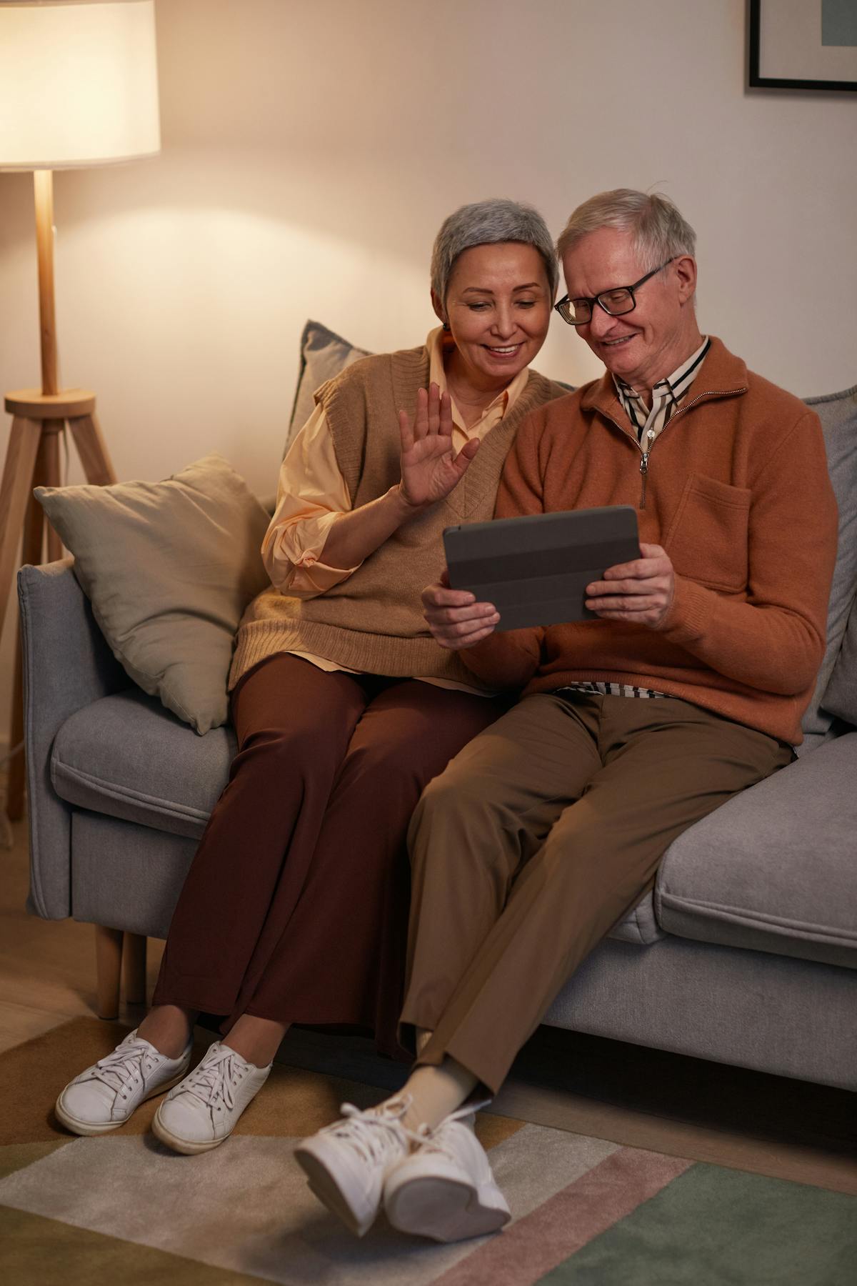 Older couple smiling while looking at a tablet together