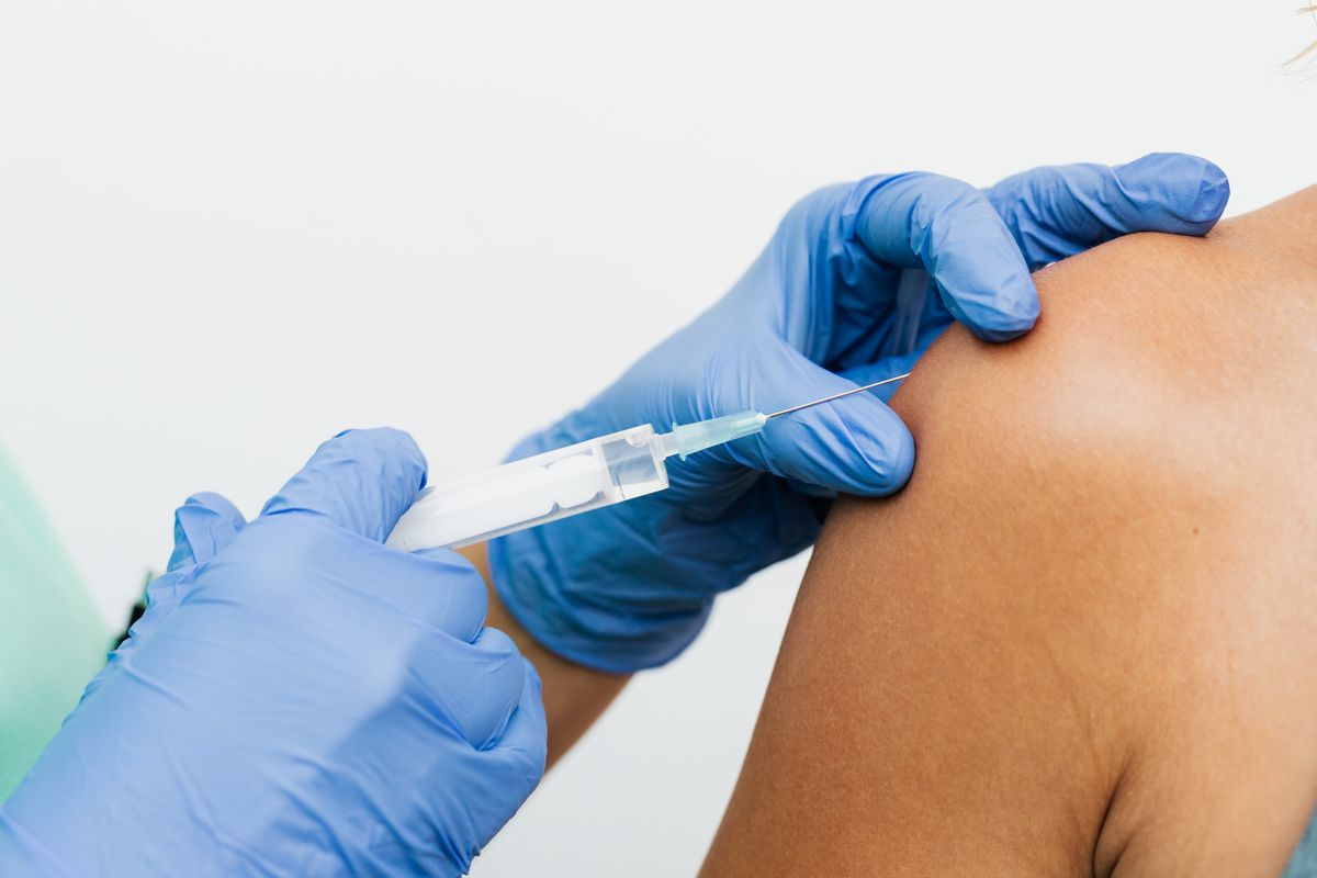 Healthcare worker administering a vaccination injection to a patient's arm